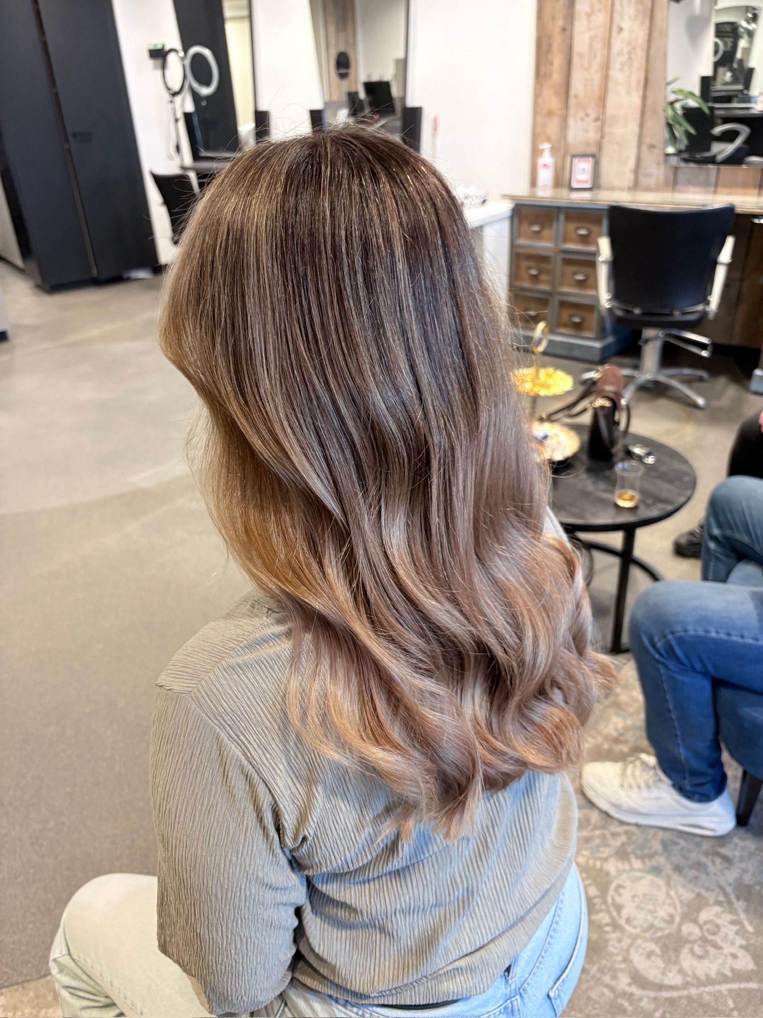 Lange bruine golven met balayage, van achteren gezien in de salon